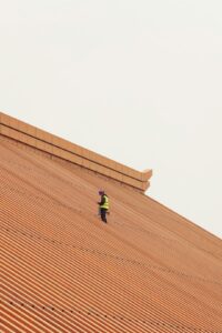 A residential roof with solar panels, snow guards, layered underlayment, and an attic ventilation detail.